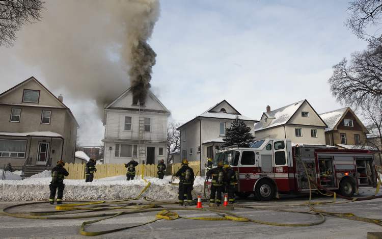 KEN GIGLIOTTI / WINNIPEG FREE PRESS archives
Firefighters reload oxygen tanks after searching the third floor of a rooming house at 614 Maryland St. that caught fire last January. For the last two years, rooming houses have been inspected only after a complaint.