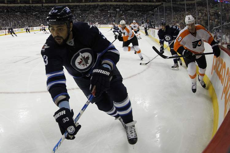 Trevor Hagan / Winnipeg Free Press
Winnipeg Jets' Dustin Byfuglien (33) reaches for the puck as he is pursued by Philadelphia Flyers Mike Knuble (9) at MTS Centre in Winnipeg Saturday. The Jets won 4-1.