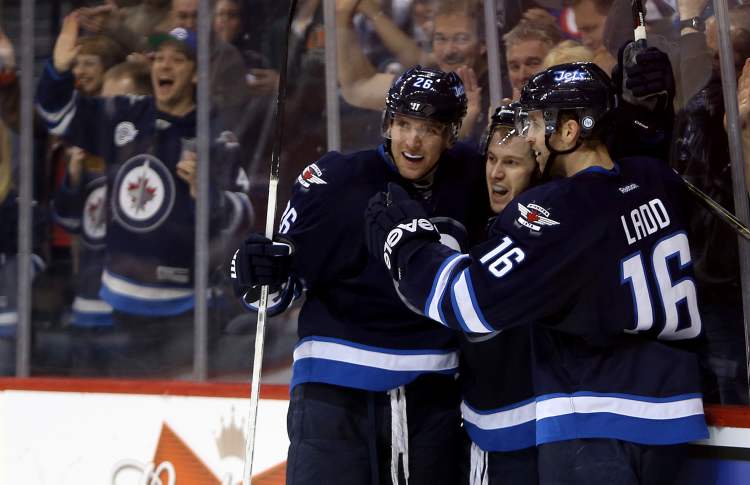 TREVOR HAGAN / WINNIPEG FREE PRESS
Winnipeg Jets' Blake Wheeler (26), Bryan Little (18) and Andrew Ladd (16) celebrate after Little scored during second period NHL hockey action against the Philadelphia Flyers at MTS Centre in Winnipeg, Saturday. The Jets ended a five-game losing streak, beating the Flyers 4-1.