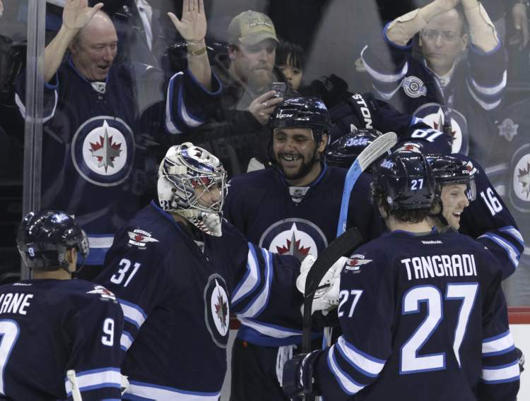 MIKE DEAL / WINNIPEG FREE PRESS
The Jets' Dustin Byfuglien (centre) celebrates his game-winning goal in overtime with his fellow Jets at the end of their 4-3 win over the Carolina Hurricanes.