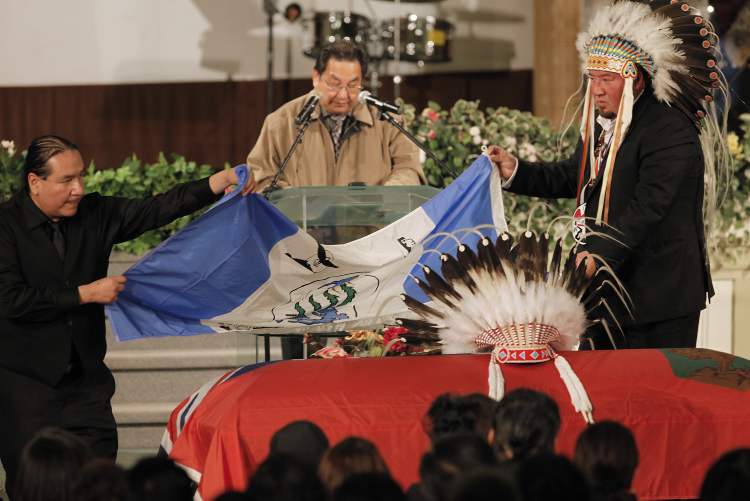 JOHN WOODS / WINNIPEG FREE PRESS
Harper's son, Bruce, (left), Grand Chief Derek Nepinak (right) and Jonathan Flett place an Island Lake flag on Harper's casket.