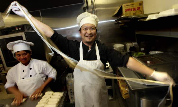 Phil Hossack / Winnipeg Free Press
Jun Yang 'rips' a strip of freshly made noodles
