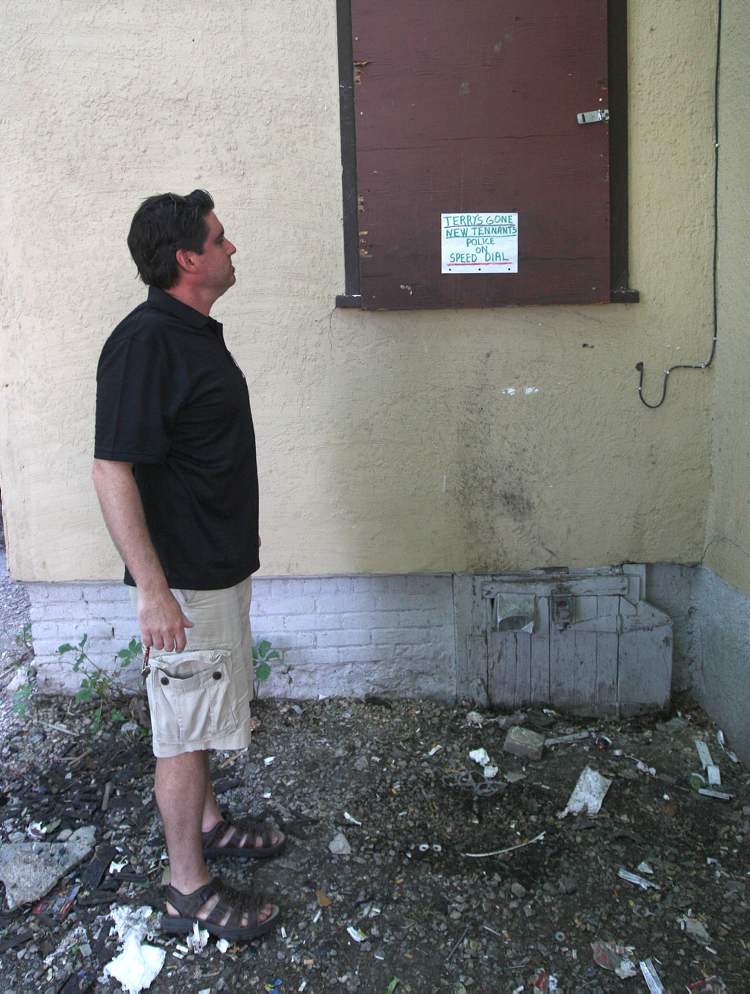 JOE BRYKSA / WINNIPEG FREE PRESS
Landlord Steve Tait views a warning a new tenant posted on the rear window of her room that police will be called if customers of a drug dealer who used to live there drop around. It was formerly a drive-thru window for the dealer's clientele.
