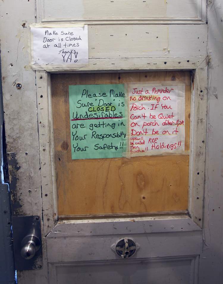JOE BRYKSA / WINNIPEG FREE PRESS
Signs inside the main door at a Spence Street rooming house reminds tenants to 'please make sure door is closed' to prevent 'undesirables' from entering, and that drinking and loud noises on the front porch are not allowed.
