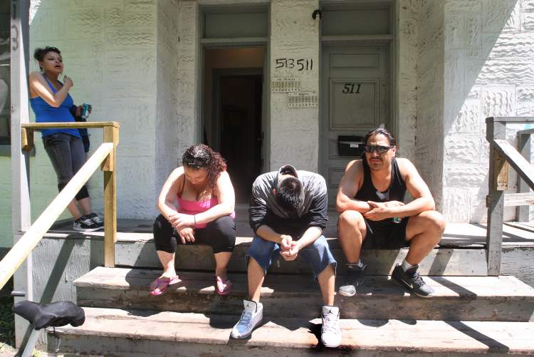JOE BRYKSA / WINNIPEG FREE PRESS
People gather on the front porch of a Spence Street rooming house.
