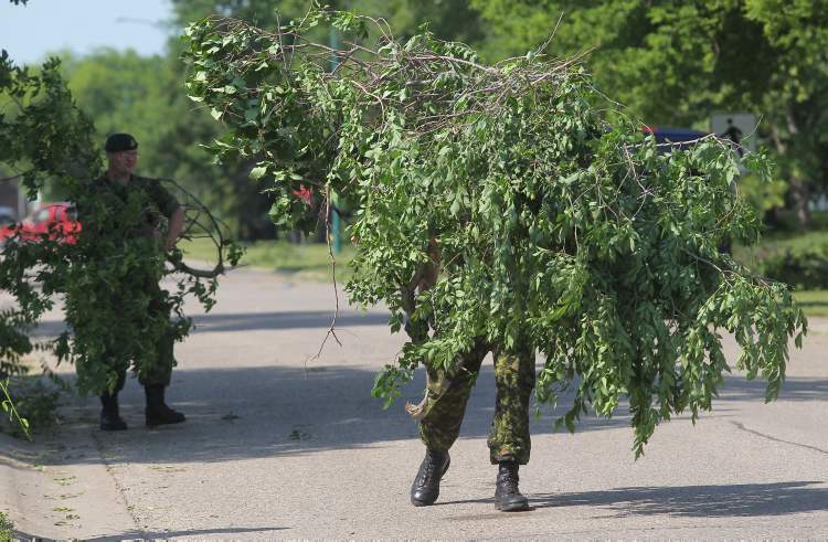 Bruce Bumstead/Brandon Sun
Soldiers with the 1 Royal Canadian Horse Artillery help remove debris at CFB Shilo on Friday morning after a severe thunderstorm with high winds hit the area Thursday.