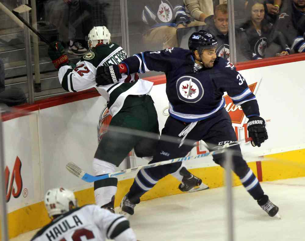 Phil Hossack / WInnipeg Free Press
Winnipeg Jets defenceman Dustin Byfuglien keeps Nino Niederreiter of the Minnesota Wild out of the play during the first period of Thursday night's game at the MTS Centre.