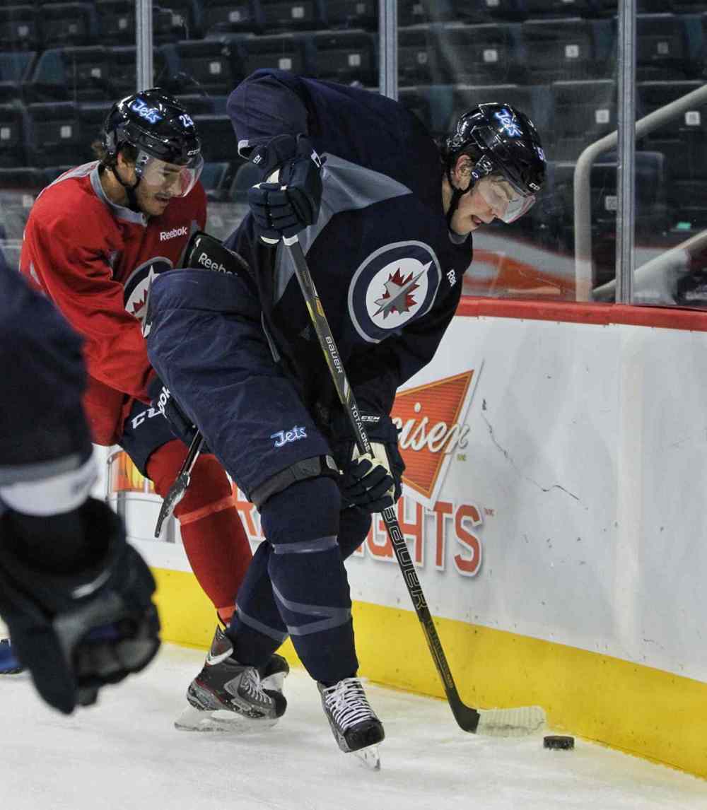 Mike Deal / Winnipeg Free Press
Prized prospect Adam Lowry (right) tries to control the puck while Zach Redmond works him into the corner.