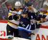 BORIS MINKEVICH / WINNIPEG FREE PRESS
Winnipeg's Jim Slater and Boston's Kevan Miller mix it up along the boards (above) in the second  period. At left, Boston's Loui Eriksson celebrates his OT winner.