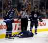 TREVOR HAGAN / WINNIPEG FREE PRESS
The referee summons trainers and medical personnel after Jacob Trouba crashed head-first into the boards during the second period of Friday night's game.