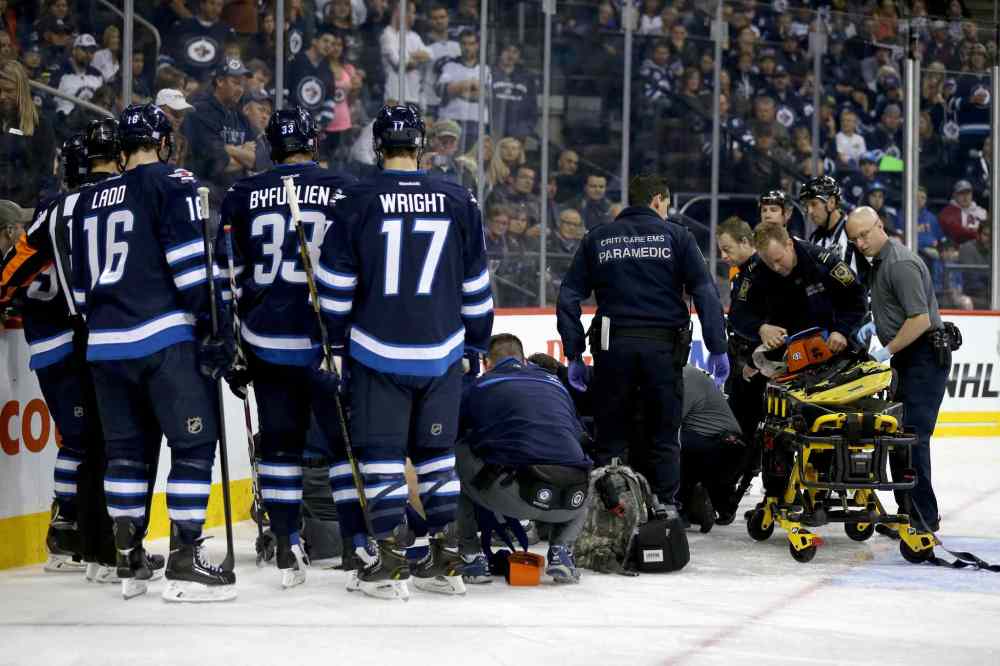 TREVOR HAGAN / WINNIPEG FREE PRESS
Winnipeg Jets defenceman Jacob Trouba lays on the ice as he is tended to by emergency personnel after going hard into the boards head first in the second period.