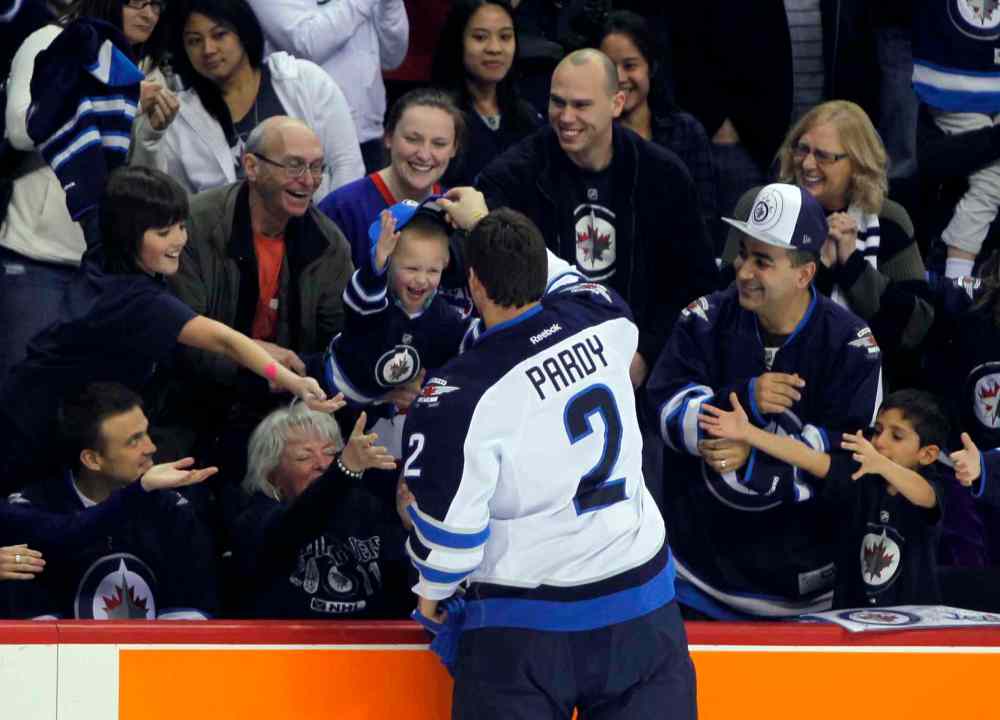 PHOTOS BY BORIS MINKEVICH / WINNIPEG FREE PRESS
Jets defenceman Adam Pardy gives a hat to a lucky Jets fan during the skills competition at MTS Centre Wednesday night.