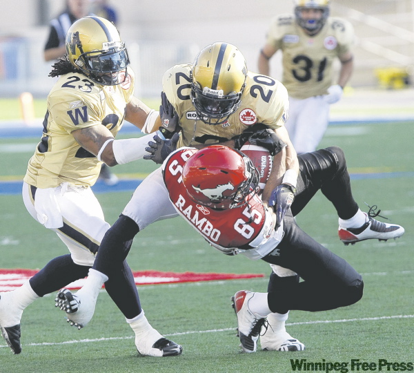 JOE.BRYKSA@FREEPRESS.MB.CA
Bombers tacklers Siddeeq Shabazz (23) and Jonathan Hefney lay down the law on Calgary Stampeders receiver Ken-Yon Rambo during the Bombers’ 42-30 win Friday.