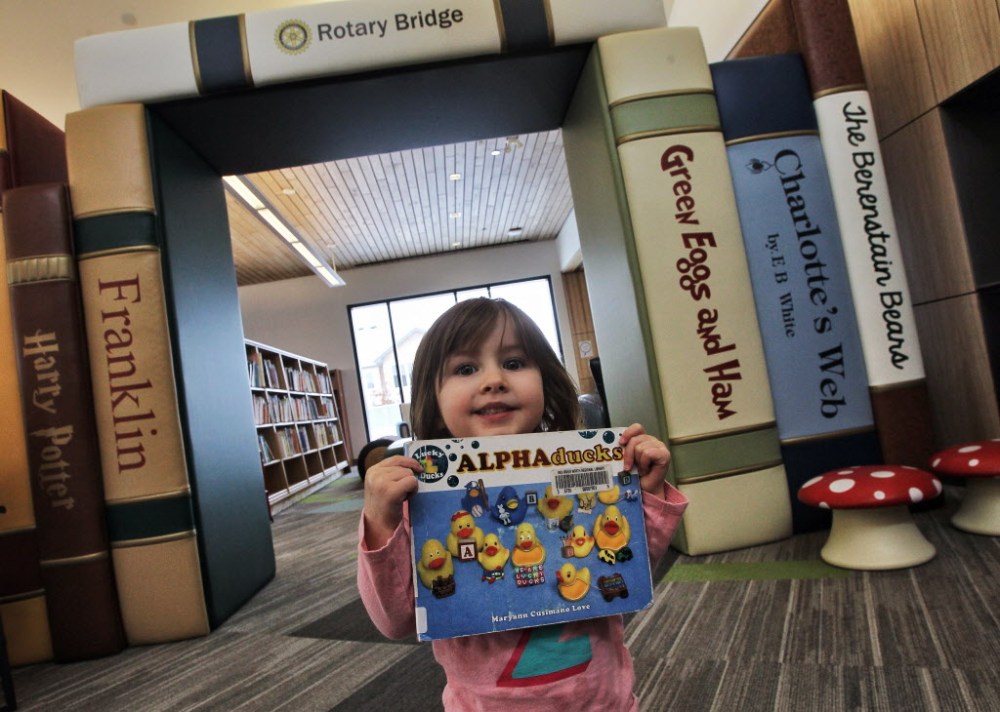 MIKE DEAL / WINNIPEG FREE PRESS
Evy Galashan, 2, shows a favourite book during a visit to the recently opened Gaynor Family Regional Library in Selkirk.