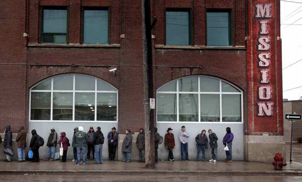 Phil Hossack / Winnipeg Free Press files
Some of Winnipeg's homeless line up outside Siloam Mission in this 2014 file photo.
