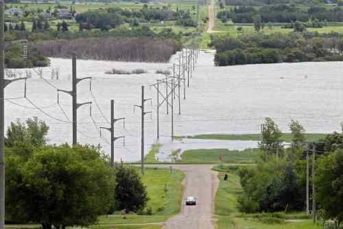 Tim Smith / Brandon Sun
Water from the Assiniboine River covers farmland bordering Brandon's Grand Valley Road on Sunday afternoon.