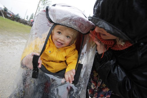 John Woods / Winnipeg Free Press
Miriam Recksiedler and her mom Jillian check to see if the rain has stopped as music fans cover up on a very wet final day of Folk Fest Sunday, July 13, 2014.