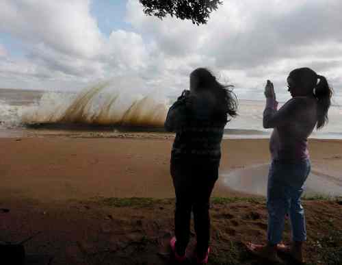 Ken Gigliotti / Winnipeg Free Press
Freya Croatto  (left) and Alana Hing take pictures of crashing waves that flooded most of Winnipeg Beach.