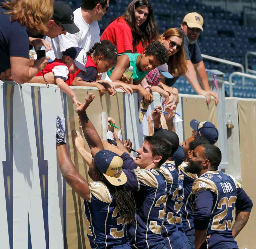 KEN GIGLIOTTI / WINNIPEG FREE PRESS
Blue Bombers running back Paris Cotton (left) gives a young fan a high-five during a post-practice autograph session at Investors Group Field Wednesday afternoon.