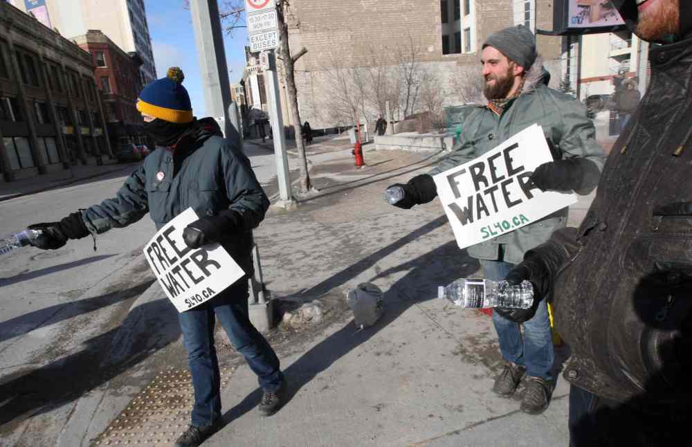 JOE BRYKSA / WINNIPEG FREE PRESS
Chuck Wright, right, and a small group of concerned citizens handed out bottles of water with a statement on the labels to highlight the irony of a 17-year boil water advisory in Shoal Lake #40, the source of Winnipeg's water.