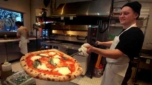PHIL HOSSACK / WINNIPEG FREE PRESS
Sean Davids shows off a margherita pizza at the south Osborne Street restaurant.