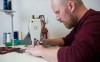 DAVID LIPNOWSKI / WINNIPEG FREE PRESS
Chris (Keener) Dougherty works on letters using a sewing machine. Details such as fonts, stitch-widths and threading separate an authentic sports jersey from a fake, he says.