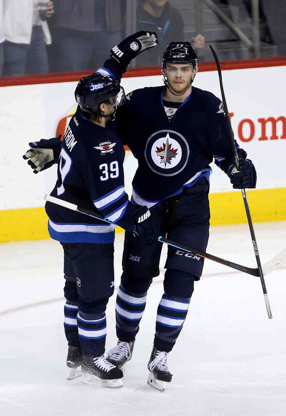 Trevor Hagan / Winnipeg Free Press
Winnipeg Jets' Toby Enstrom (39) and Adam Lowry (17) celebrate after Lowry scored against the Calgary Flames' during third period NHL hockey action on April 11.