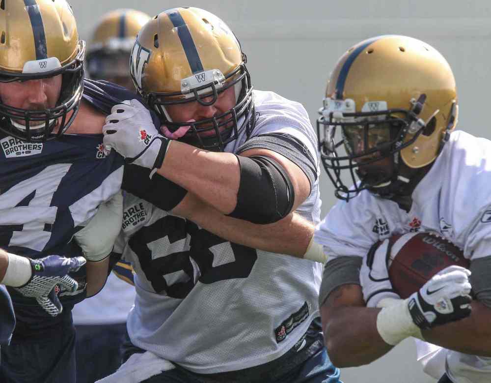 MIKE DEAL / WINNIPEG FREE PRESS
Dominic Picard (centre) tries to control Zach Anderson (left) during training camp Monday.