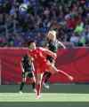 PHIL HOSSACK / WINNIPEG FREE PRESS
New Zealand's #12 Betsy Hassett and CHina's # 9 Shanshan Wang look for the header rebound in FIFA action at Investor's FIeld in WInnipeg Monday.