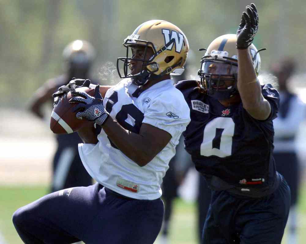 BORIS MINKEVICH / WINNIPEG FREE PRESS
Jhomo Gordon (left) hauls in a pass while being pestered by Shaquille Richardson at Blue Bombers training camp Wednesday.