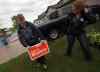 Daniel Blaikie pushes a campaign sign into a transcona lawn Wednesday evening assisted by Breigh Kusmack. The sign at 171 Chadwick Cr. was the first in the area. (Phil Hossack / Winnipeg Free Press)