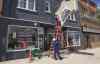 A city contractor removes the sign at the Main Street store that was selling marijuana. The store owner was arrested Tuesday afternoon. (Mike Deal / Winnipeg Free Press)