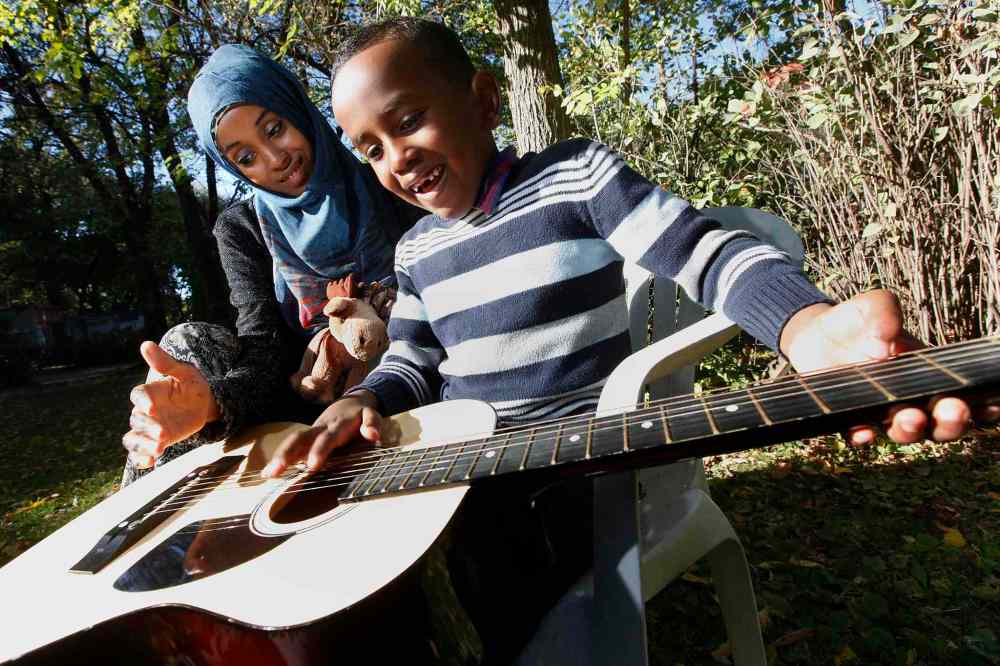 John Woods / Winnipeg Free Press
Amin and his mother Sahra Ali Ahmed play the guitar that Art Elaschuk gave to him after hearing that they arrived Sunday at the Canadian border seeking asylum.