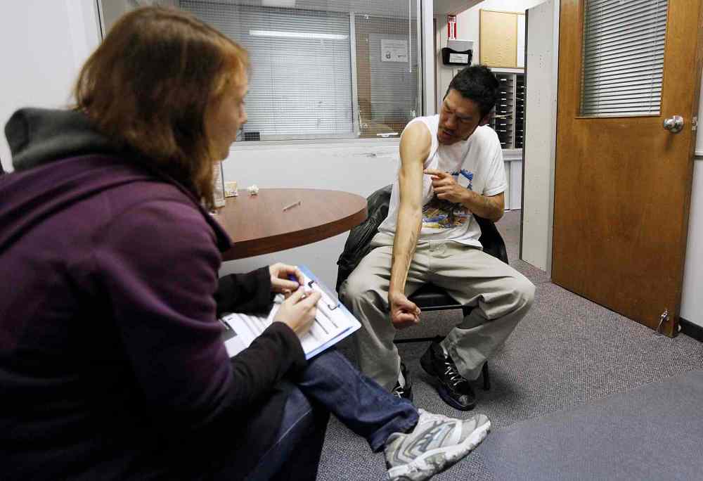 Winnipeg Free Press
Dougie Bruce shows his gunshot scars as he speaks to a volunteer at the Main Street Project during Sunday's census of the city's homeless.