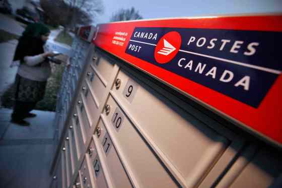 John Woods / Winnipeg Free PressA woman collects mail at a community mailbox Monday after Canada Post has suspended installation of these mailboxes until it hears from Canada's new federal government.