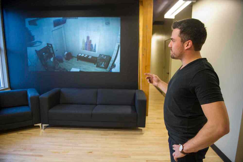 David Lipnowski / Winnipeg Free Press
Epic Escape Winnipeg co-owner Wade Gamey (right) monitors Winnipeg Free Press reporter Geoff Kirbyson and son Alex as they struggle to make sense of clues inside a locked room.