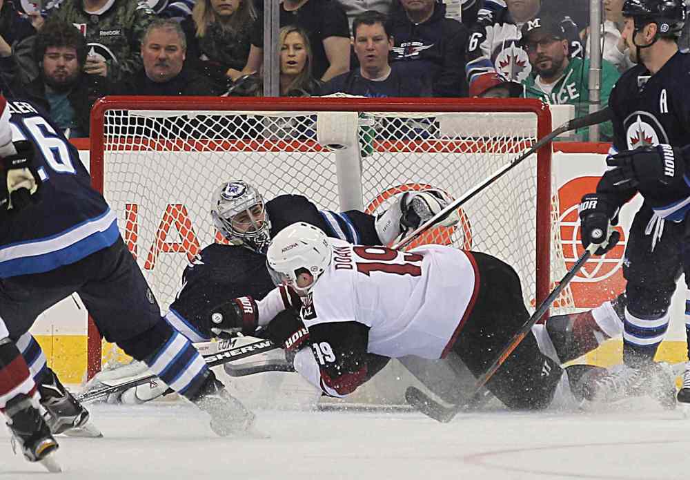 Ruth Bonneville / Winnipeg Free Press
Ondrej Pavelec gets knocked down by Arizona Coyotes' Shane Doan during the second period last night at the MTS Centre.
