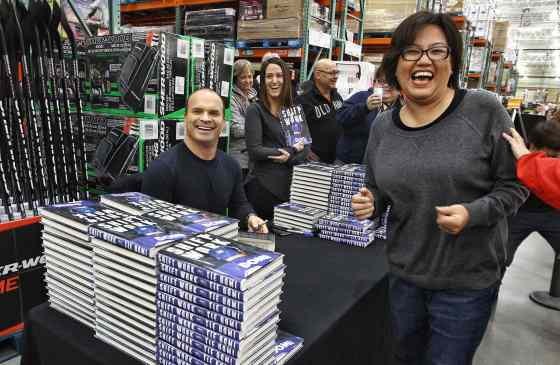 Brenda Frogg laughs while her favourite hockey legend Tie Domi signs his book for her at the Costco on McGillivray Boulevard Sunday afternoon. Domi was signing copies of his memoir, Shiftwork.
