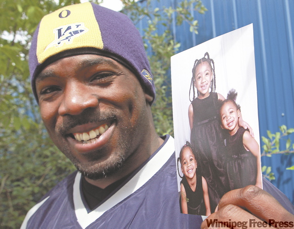 KEN GIGLIOTTI / WINNIPEG FREE PRESS
A proud Ike Charlton shows off a shot of his daughters (from left) Iniya, Tiah and Imari. 'That's why I play and why I plug along -- because they're here.'