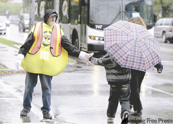 TREVOR HAGAN / WINNIPEG FREE PRESS
Bob Sweet regularly stops traffic in front of St. Ignatius School with his orange flag and the wacky outfit of the day.