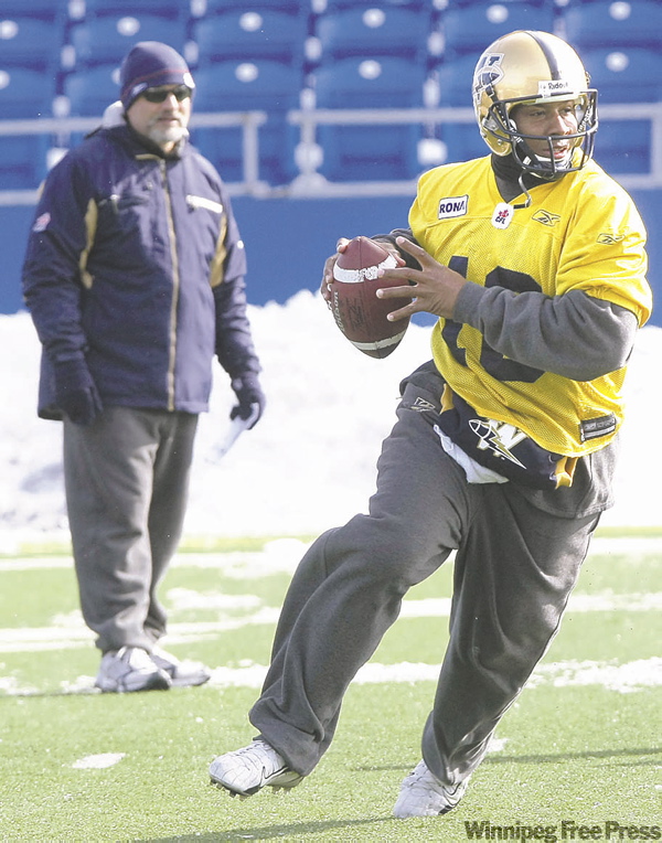 JOE.BRYKSA@FREEPRESS.MB.CA
Bomber QB Michael Bishop scrambles, right, as coach Manny Matsakis watches during a snowy practice Saturday,