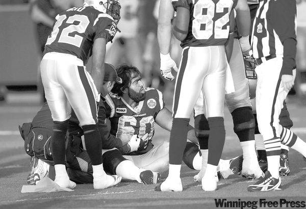 BORIS MINKEVICH / WINNIPEG FREE PRESS
Winnipeg offensive lineman Obby Khan (60) suffers the ill effects of a Lions' cheap shot. The Bombers' loss took the wind out of the team's sails as well.