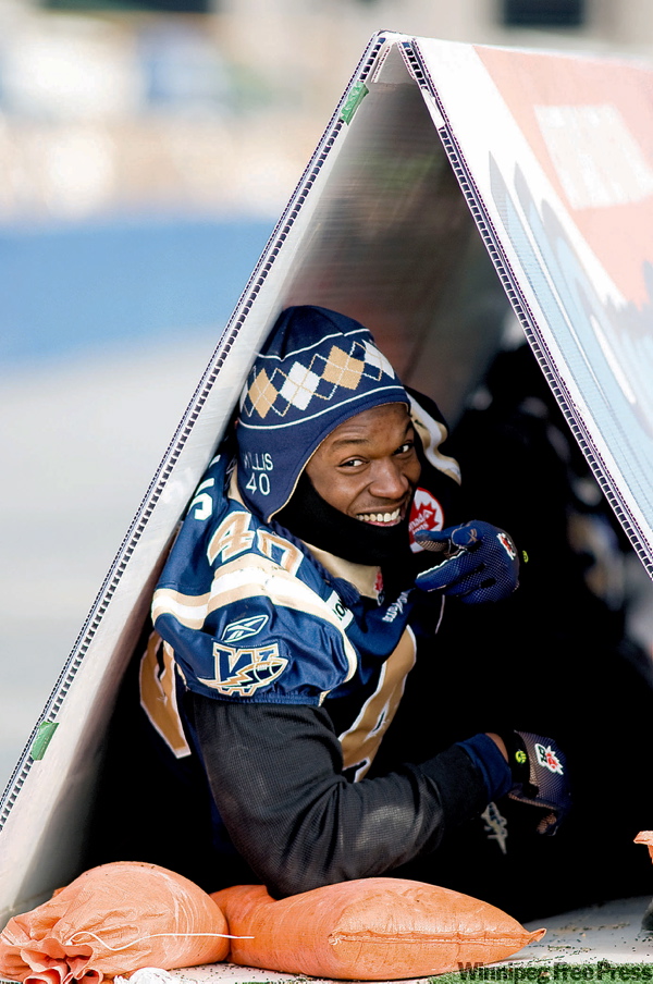 DAVID LIPNOWSKI / WINNIPEG FREE PRESS
Odell Willis was leading a sheltered life Friday while his Winnipeg Blue Bomber teammates worked out in chilly conditions at Canad Inns Stadium. Willis was seeking refuge inside a signboard advertisement.