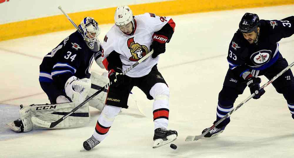 PHIL HOSSACK / WINNIPEG FREE PRESS
Ottawa Senator #93 Mika Zibanejad steps on the puck in front of Winnipeg Jet Dustin Byfuflien and netminder #34 Michael Hutchinson during the first period at the MTS Center Wednesday.