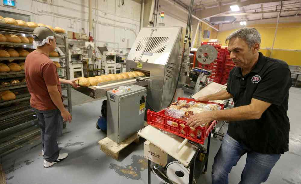 JASON HALSTEAD / WINNIPEG FREE PRESS
KUB Bakery co-owner Ross Einfeld (right) and employee Avelino Ordoñez work on orders.