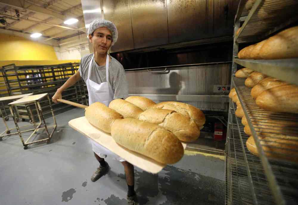 JASON HALSTEAD / WINNIPEG FREE PRESS
Employee Justin Ross puts loaves of rye onto a cooling rack.