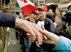 A Canadian veteran reaches out to shake a child’s hand during a parade. Canadians can now meet veterans and hear their stories on the Internet, too.