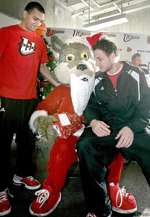 WAYNE.GLOWACKI@FREEPRESS.MB.CA
Wesmen players Craig Penniston, left, and Mike James pass on their holiday request to Santa, who looks a lot like mascot Wes Lee Coyote.