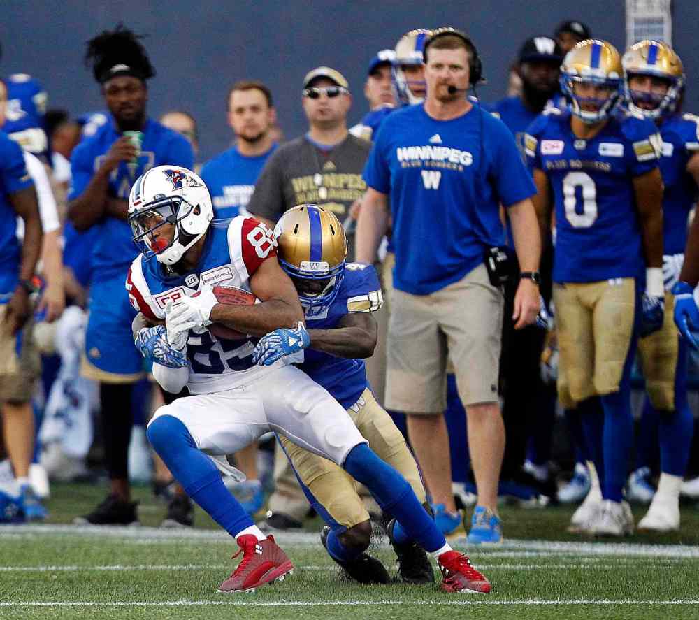 PHIL HOSSACK / WINNIPEG FREE PRESS
Montreal Alouette B.J. Cunningham succumbs to Winnipeg Blue Bomber #4 Roc Carmichael the first half.