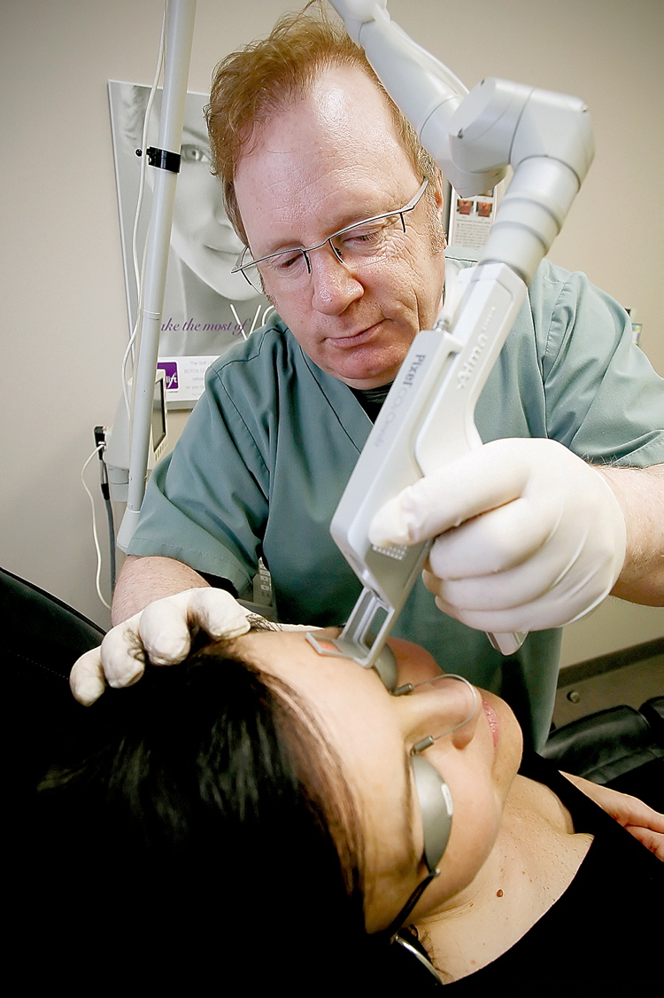 JOHN WOODS / CANWEST NEWS SERVICE
Dr. Earl Minuk applies a treatment of fractional CO2 laser surfacing to a patient.